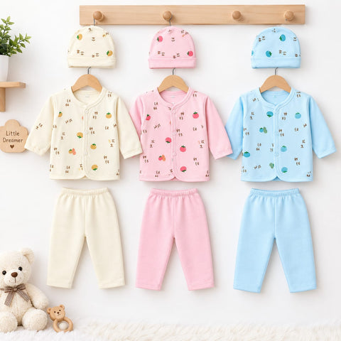 Three sets of baby clothing displayed on wooden hangers against a white wall: a cream long-sleeve top with matching cream pants, a pink long-sleeve top with matching pink pants, and a light blue long-sleeve top with matching blue pants. Each set includes 