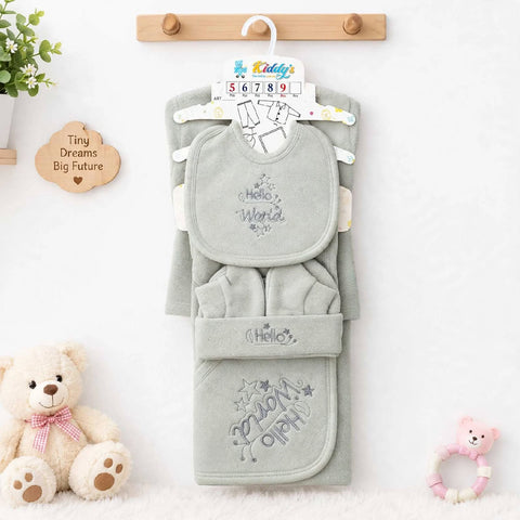 A baby clothing set in a soft sage green color, including a bib, foot mitt, and bootie, hanging on a wooden hanger. The set features embroidered details such as 'Hello World' on the bib and 'You Are Worth It' with stars on the bootie.