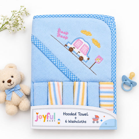 A blue hooded baby towel set with a gingham border, embroidered camper design, and six striped washcloths, displayed on a white background with a teddy bear, baby flowers, and a pacifier.