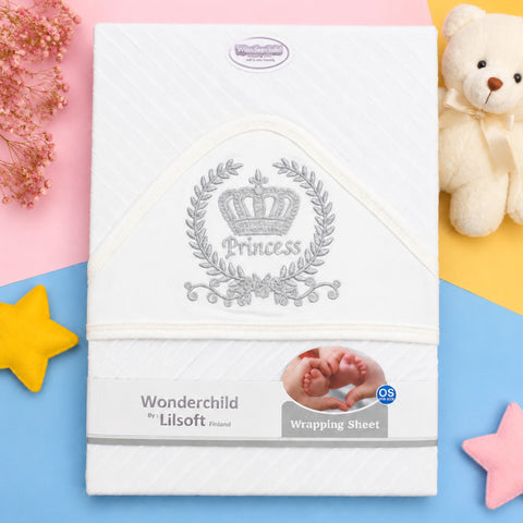 Wonderchild by Lilsoft Princess wrapping sheet for newborn babies, featuring a white textured fabric with a silver embroidered crown and laurel wreath design. The sheet is displayed in a flat-lay setting with pastel pink, yellow, and blue background secti