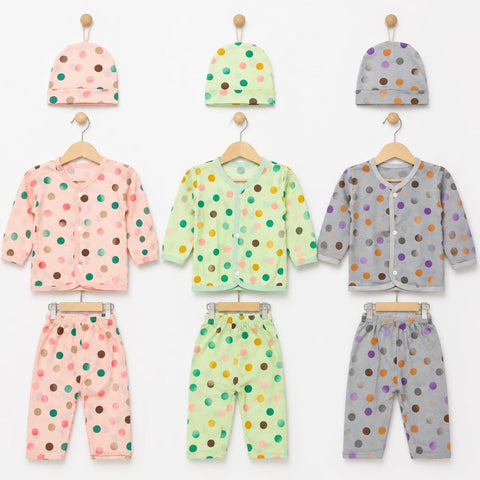 Three baby clothing sets displayed on wooden hangers against a white background, each set including a hat, long-sleeve top, and pants in soft pastel colors with multicolored polka dots. The sets are pink, mint green, and light gray.