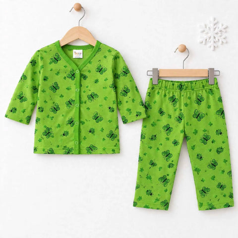 A two-piece baby clothing set consisting of a green long-sleeve button-front cardigan and matching pants, both printed with a dark green clover pattern, hanging on wooden hangers against a white wall.