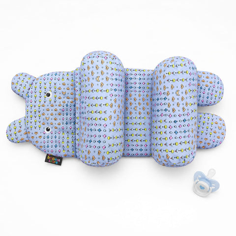 A baby support pillow shaped like a cartoon bear, featuring a light blue and purple patterned fabric with multicolored icons, shown with a pacifier on a white background.