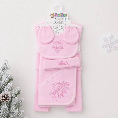 A pink baby gift set hanging on a white hanger against a light background, featuring a bib with 'Hello World' embroidery, a matching hat, and a hooded towel with 'My First Party' embroidery. Decorative pine branches and a snowflake are visible at the edge