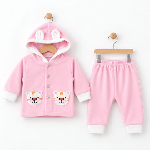 A baby clothing set consisting of a pink hooded cardigan with bunny ears and tiger face patches, and matching pink pants with white cuffs, displayed on wooden hangers against a white background.