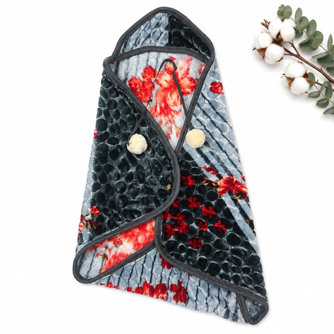 A plush fleece baby wrap or swaddle blanket with a black and red floral print, featuring a textured black chevron pattern on one side and a red floral print on a light blue-gray background on the other. It is styled on a white background with a decorative
