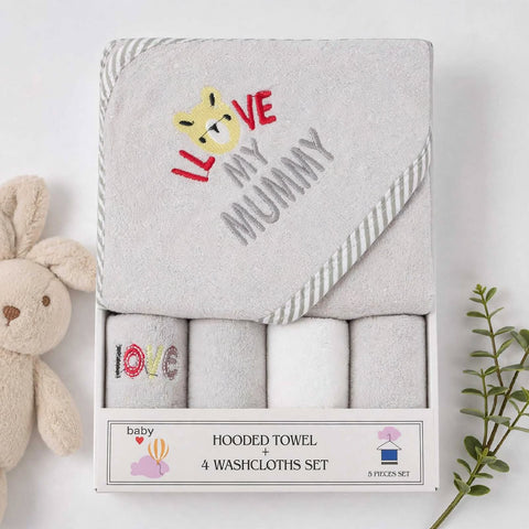 A boxed baby gift set containing a hooded towel and four washcloths. The main towel is light gray with embroidered text reading 'I LOVE MY MUMMY' and a small yellow animal face.