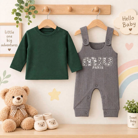 A baby clothing set displayed on wooden hangers against a decorated wall. The set includes a dark green long-sleeve top and a heather gray overall jumpsuit with 'COCO PARIS' printed on the chest.