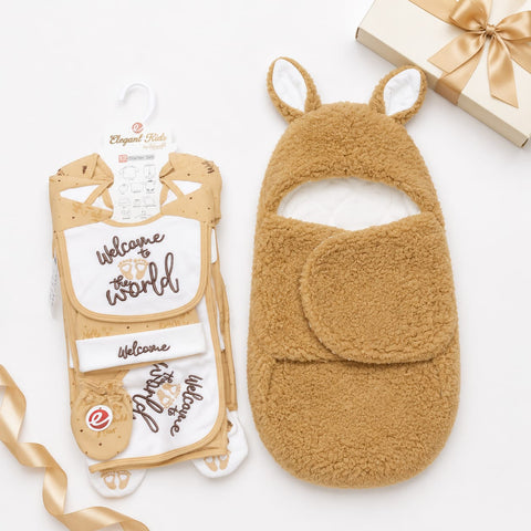 A baby gift set featuring a tan fleece kangaroo wrap and a matching cream and tan bib with 'Welcome to the world' embroidery, displayed on a white background with a gift box and ribbon.