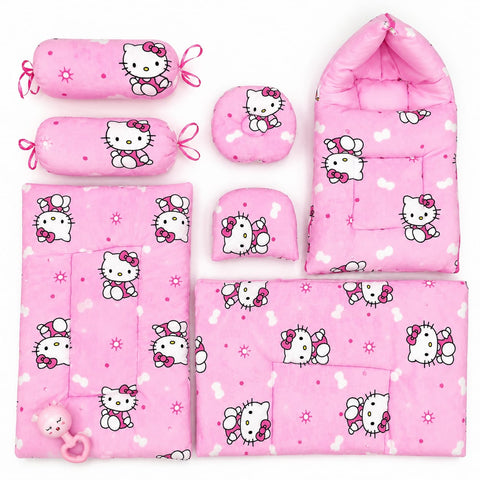 A pink baby bedding and accessory set featuring a repeating Hello Kitty cartoon print, including a footmuff, blanket, mattress pad, bassinet cover, pillow, and a pacifier, arranged on a plain white background.