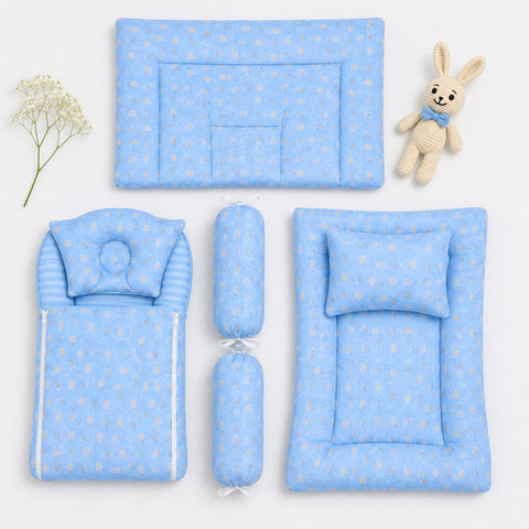 A coordinated baby bedding set arranged on a white background, including a rectangular mat with a bunny motif, a padded cushion, a striped pillow cover, two cylindrical bolsters, and a padded floor mat with a matching pillow. A small knitted bunny toy and