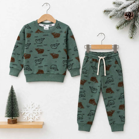 A children's two-piece pajama set in sage green, featuring a long-sleeve sweatshirt and matching jogger pants with an allover pattern of cartoon bears, hangers, and seasonal props on a white background.