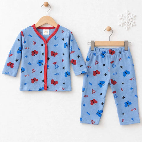 A two-piece children's pajama set consisting of a light blue long-sleeve cardigan and matching pants, decorated with a playful pattern of red ladybugs, blue butterflies, black stars, and red/blue geometric shapes. The cardigan features a red trim and snap