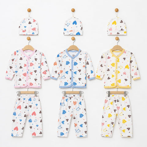 Three baby clothing sets hanging on wooden hangers against a white wall, each set including a hat, cardigan, and pants. The sets are white with colorful heart and cloud prints in pink, blue, brown, and yellow, with different trim colors (pink, blue, and y